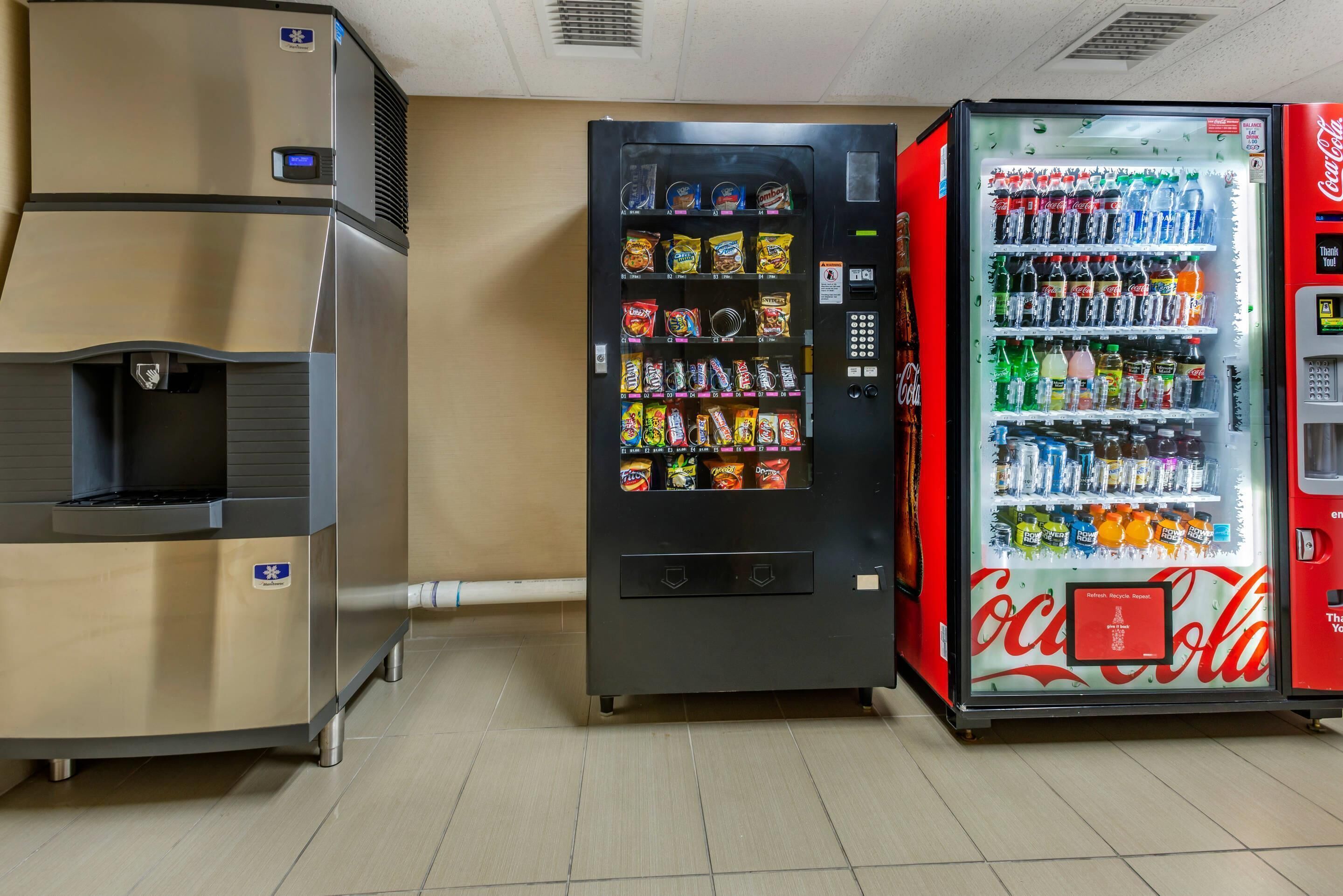 A vending machine with snacks and a Coca-Cola refrigerator.