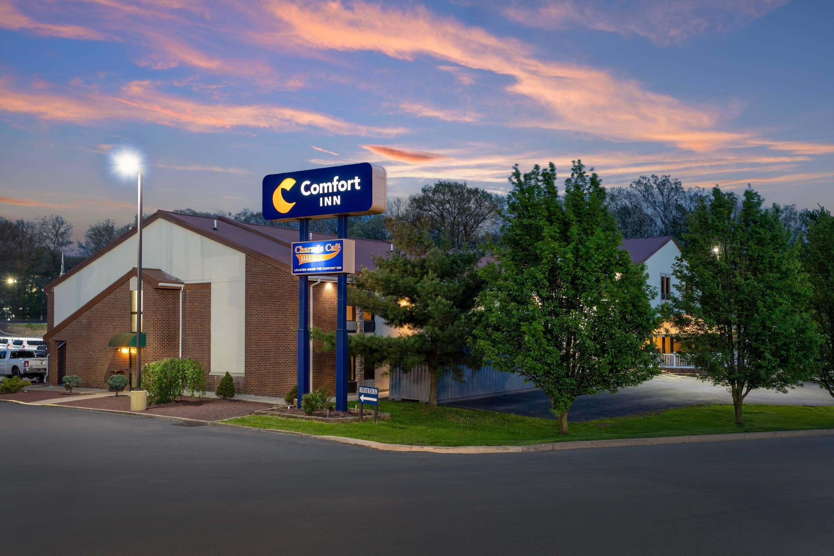 A Comfort Inn hotel with a brick facade, a signboard, and a well-maintained lawn.
