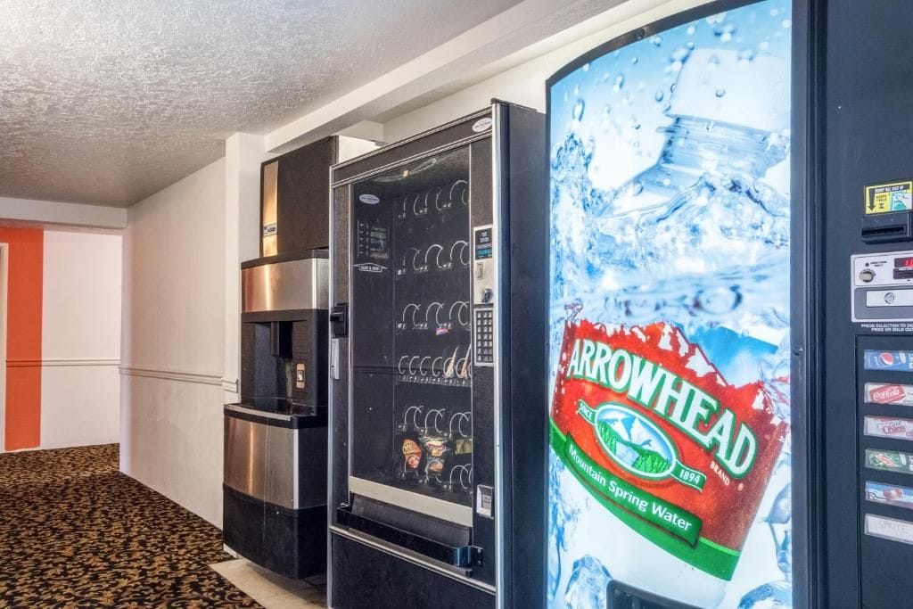 A hotel corridor with a refrigerator and a water dispenser.