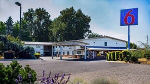 A motel with a large sign, a covered parking area, and a building labeled "OFFICE 1572". - Motel 6 Gresham, OR - Portland (Gresham)