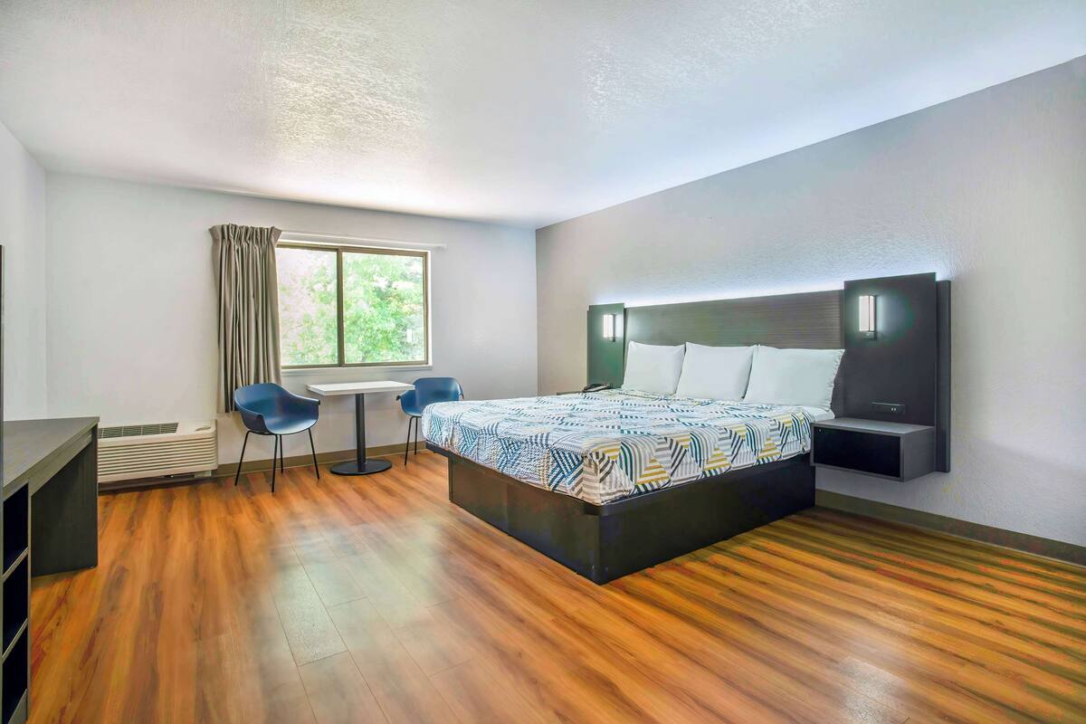 Une chambre d’hôtel moderne, dotée d’un grand lit, d’un bureau et d’une chaise.