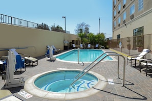 Una piscina al aire libre, sillones reclinables de piscina