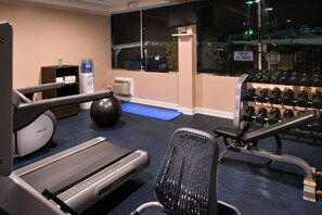 A gym with exercise equipment including a treadmill, a stationary bike, a rowing machine, a bench press, and a set of dumbbells. - Holiday Inn Express & Suites Pasadena - Los Angeles by IHG (Pasadena)