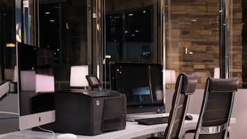 A modern office space with a desktop computer, a printer, and a chair.