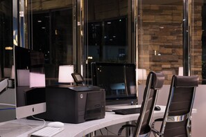 Um espaço de escritório moderno com um computador, uma impressora e uma cadeira.