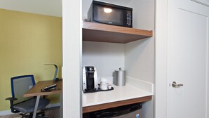 A compact hotel room with a kitchenette, a microwave, a coffee maker, and a compact dishwasher.