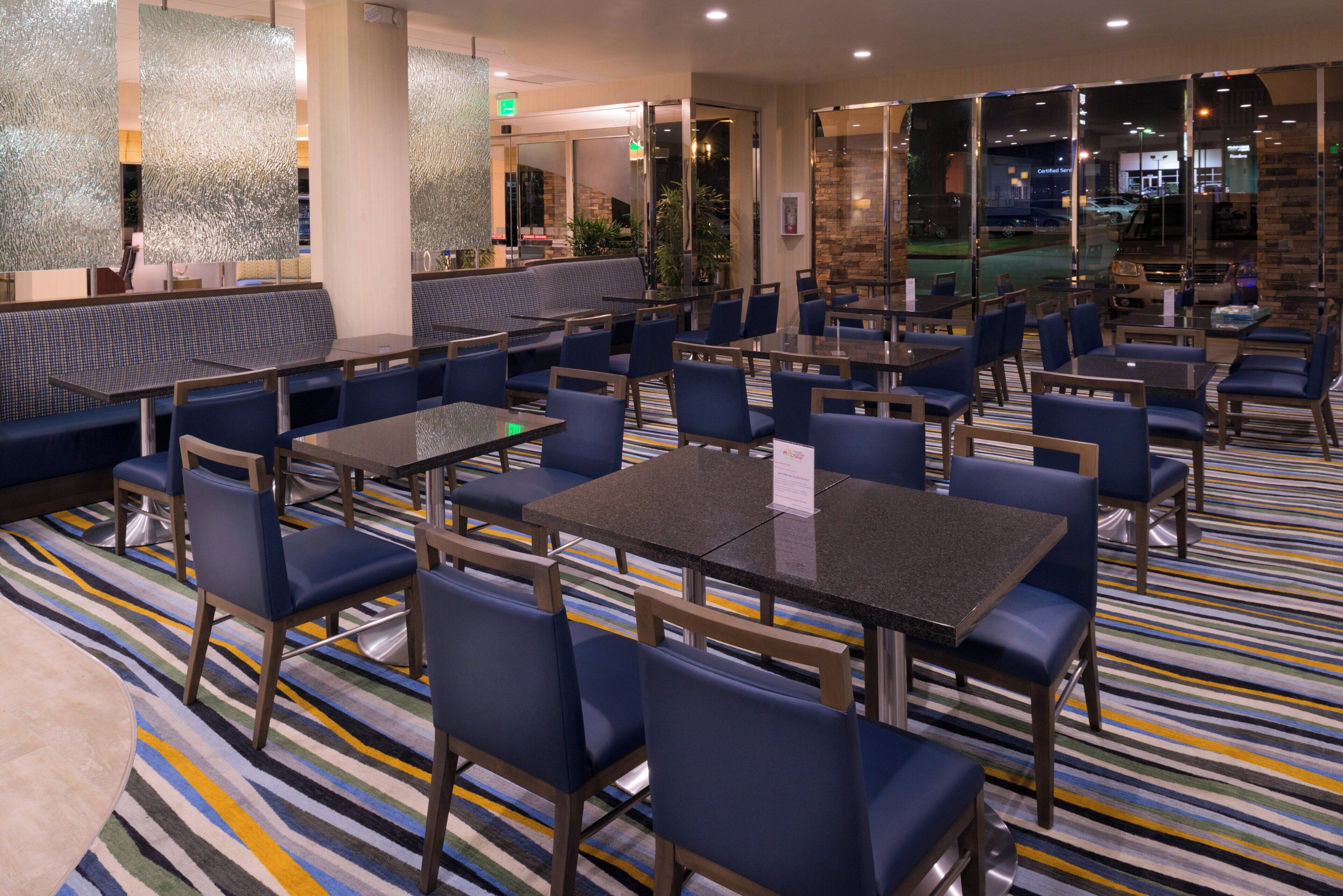 A hotel lobby with seating areas, tables, and a patterned carpet.
