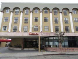 Un edificio con fachada amarilla, múltiples ventanas y un letrero que dice "RAMADA".
