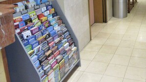 Een gang met een tijdschriftrek en een prullenbak.