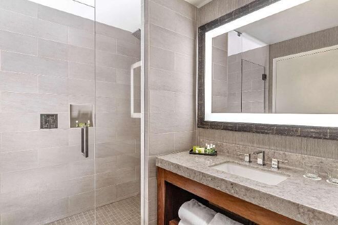 Bañera con ducha, artículos de tocador de diseñador, secador de pelo
