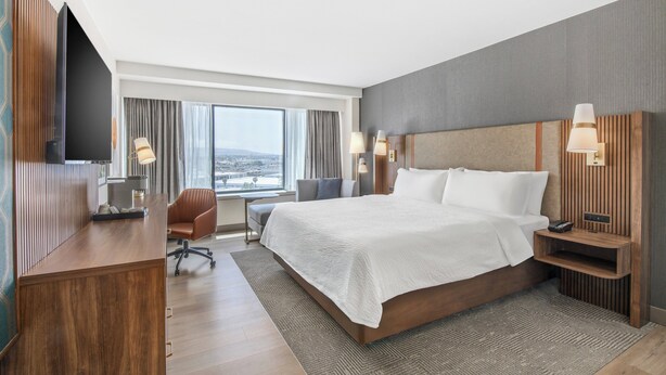 A modern hotel room with a large bed, a desk, a chair, and a TV. - Holiday Inn Los Angeles Gateway - Torrance by IHG (Torrance)