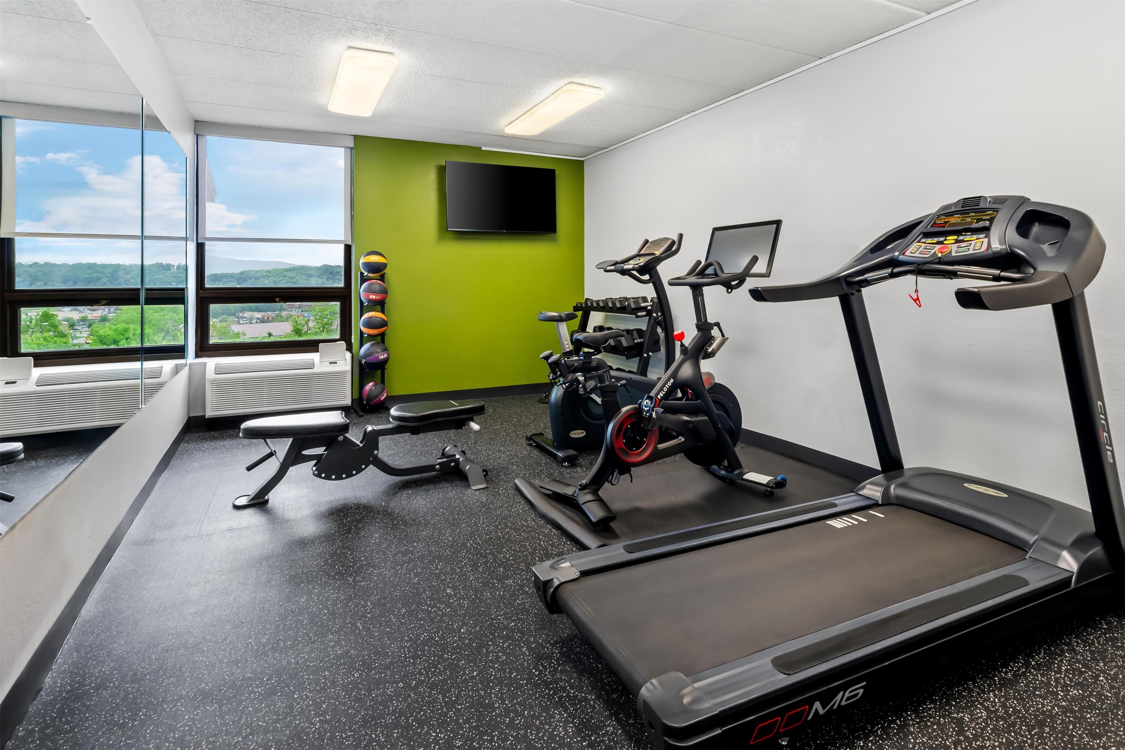 Ein Fitnessstudio mit Laufbändern, Crosstrainern und Ergometer.