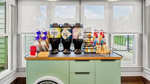 A coffee station with dispensers labeled Regular Coffee, Decaf Coffee, and Hot Water, along with various coffee cups and condiments. - Spark by Hilton Wytheville Holston Rd I 81 (Wytheville)
