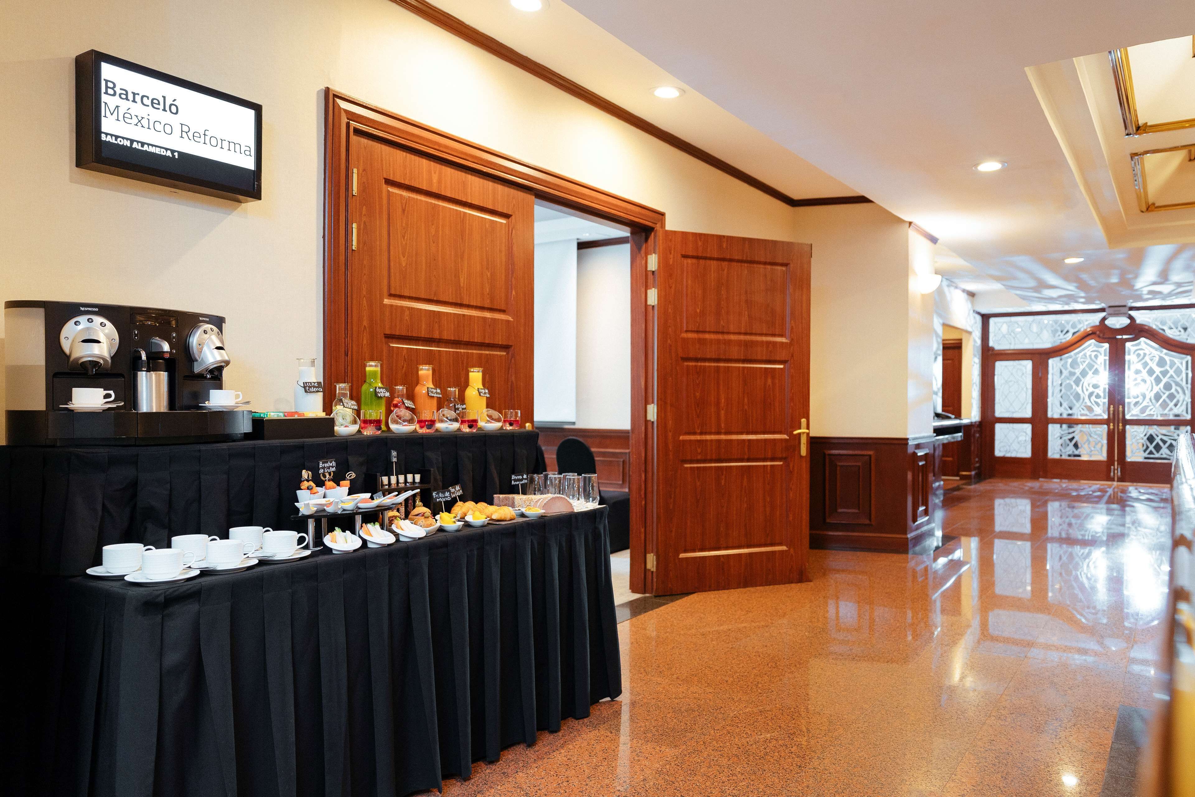 Een buffetopstelling met diverse gerechten en drankjes, een koffiehoek, en een bord dat de locatie aangeeft als 'Barcelona Mexico Reforma'.