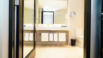 A modern bathroom with a large mirror, a double sink vanity, and a toilet.