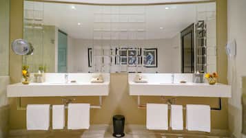 Un baño moderno con dos lavamanos, un espejo grande y un cubo de basura.