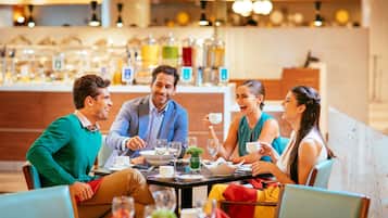 Guests can enjoy a meal together in this restaurant setting, surrounded by a selection of dishes and beverages.
