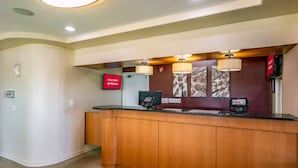 A reception desk with a flat-screen TV, a telephone, and a digital display indicating free Wi-Fi availability.