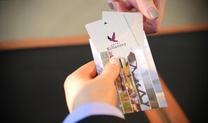 A hand holding a card with the Hotel Killarney logo and a bird illustration. - Hotel Killarney (Killarney)