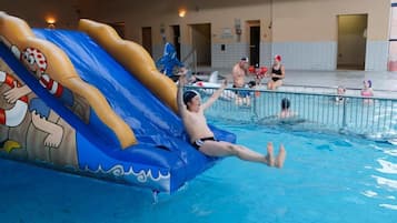 Enjoy a fun-filled swim in our pool, featuring a large inflatable slide and a secure metal fence.