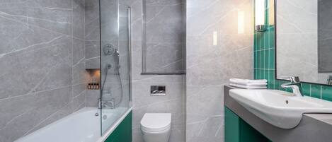 A modern bathroom with a glass-enclosed shower, a white toilet, and a sink with a green vanity.