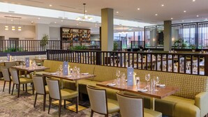 A restaurant with booths and tables, a bar area, and a view of the outside. - Hotel Killarney (Killarney)