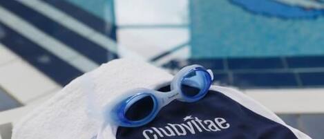 A pool area with a towel and a pair of goggles on it.