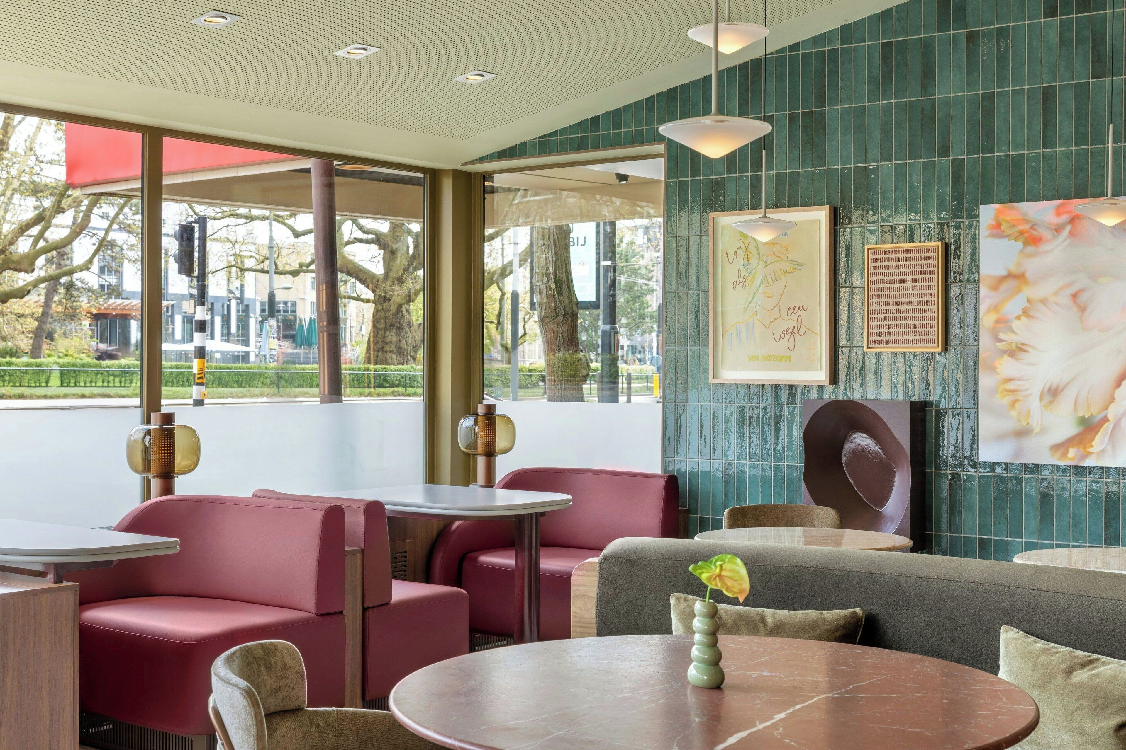 A modern interior with seating areas, tables, and artwork on the walls.