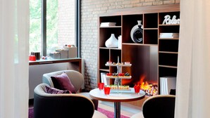 Un rincón acogedor con una mesa redonda, sillas y una estantería con aperitivos y chimenea.