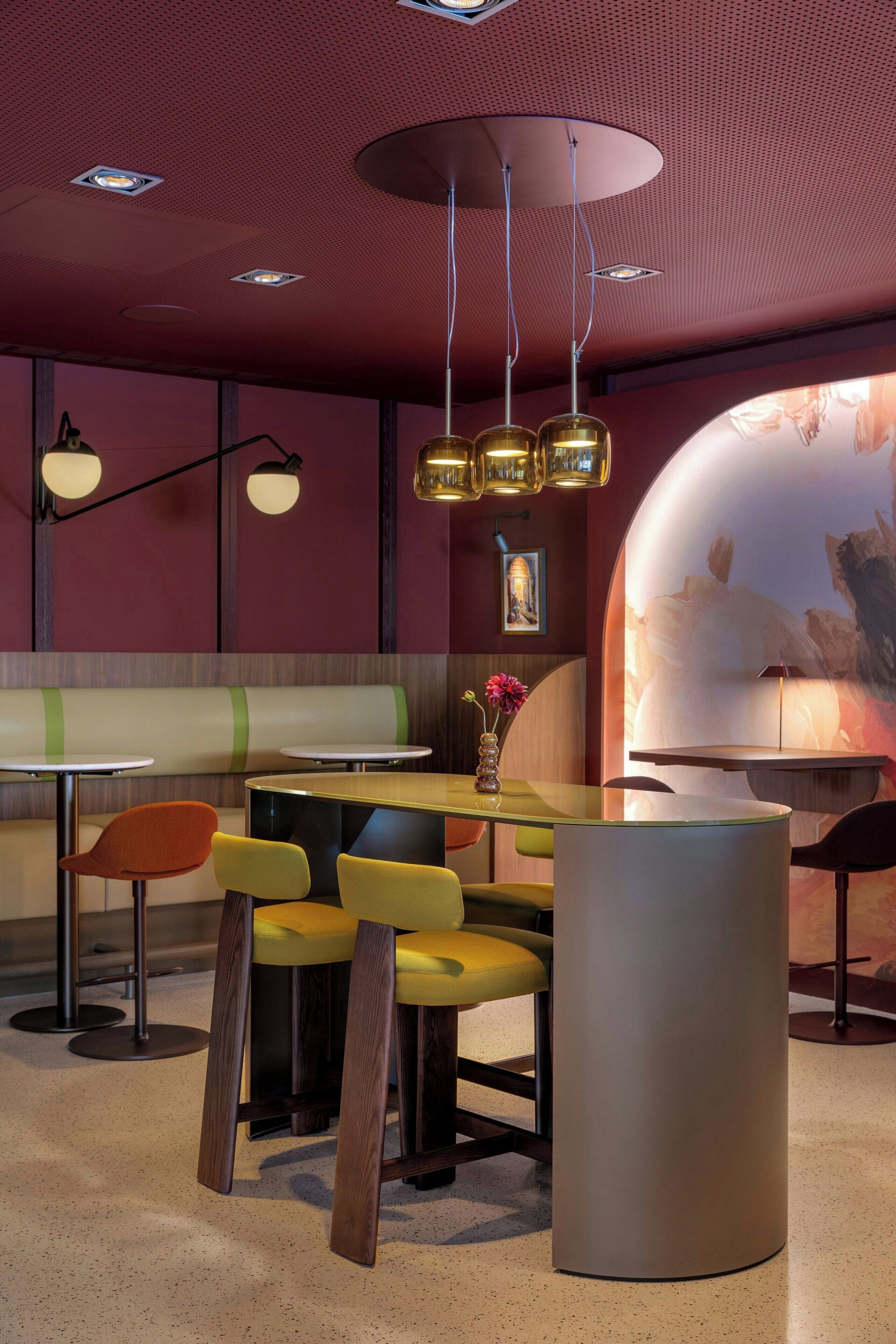 A modern restaurant interior with round tables, yellow chairs, and pendant lighting.