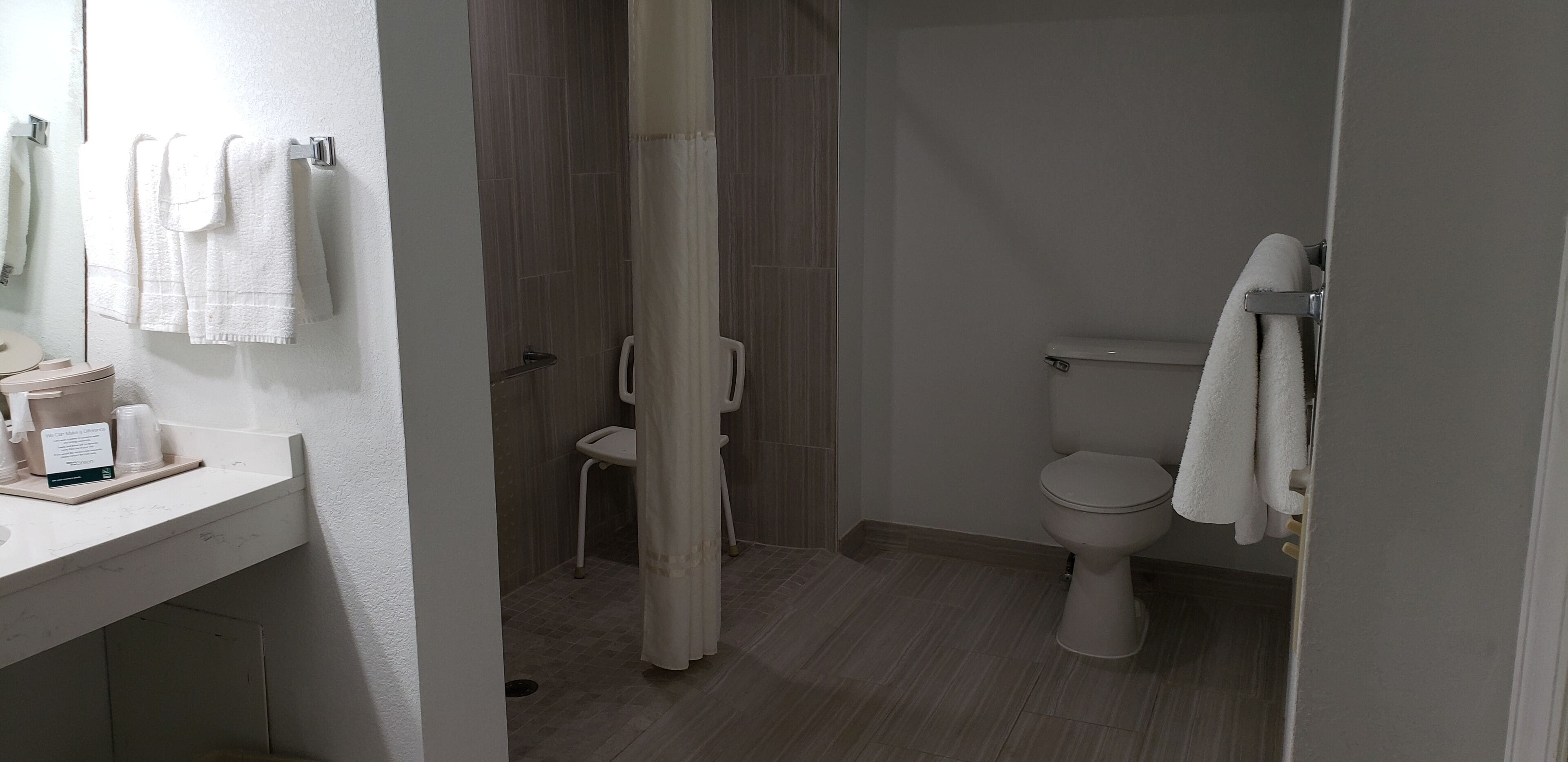 Une salle de bain avec des toilettes, un rideau de douche et un lavabo avec un miroir.