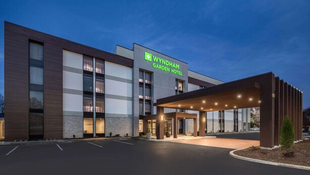 Un hôtel Wyndham Garden doté d’une façade moderne, de grandes fenêtres et d’un espace d’entrée abrité.