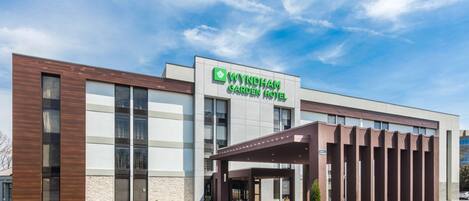 A Wyndham Garden Hotel with a modern facade, large windows, and a covered entrance area.