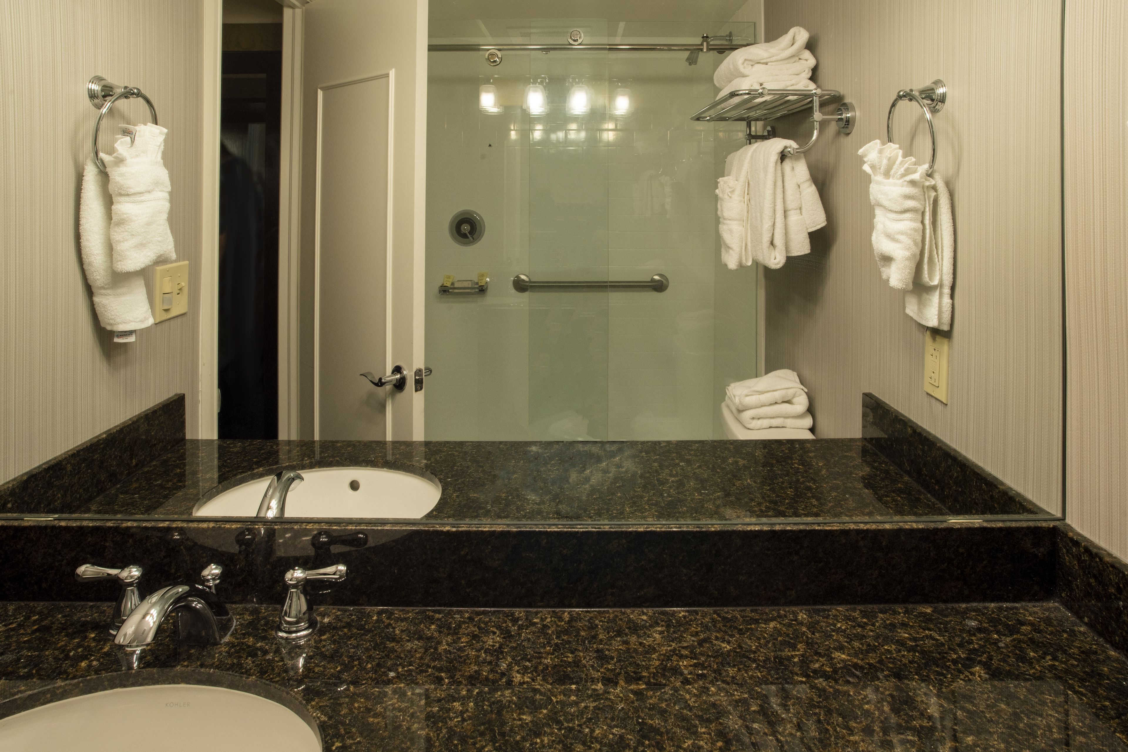 Une salle de bain équipée d’un lavabo, d’un miroir et d’une douche à parois en verre.