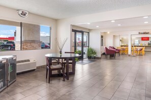 Eine Hotelhalle mit Essbereich, Frühstücksbereich und Blick ins Freie.