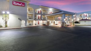 A Red Roof Inn with a multi-story structure, a covered parking area, and a well-lit entrance.