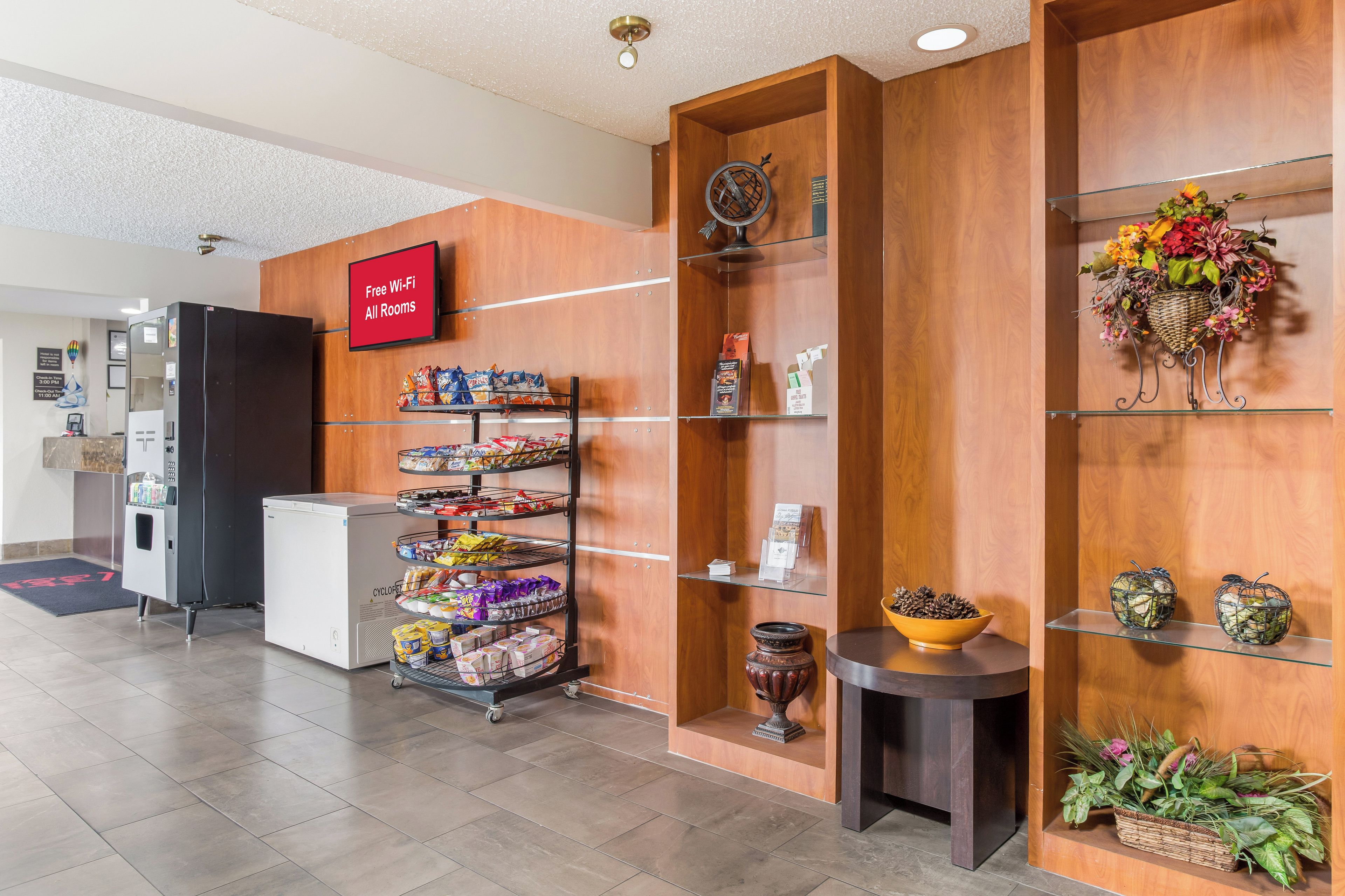 Un hall d’hôtel équipé d’un distributeur automatique de collations, d’une machine à café et d’un comptoir de réception.