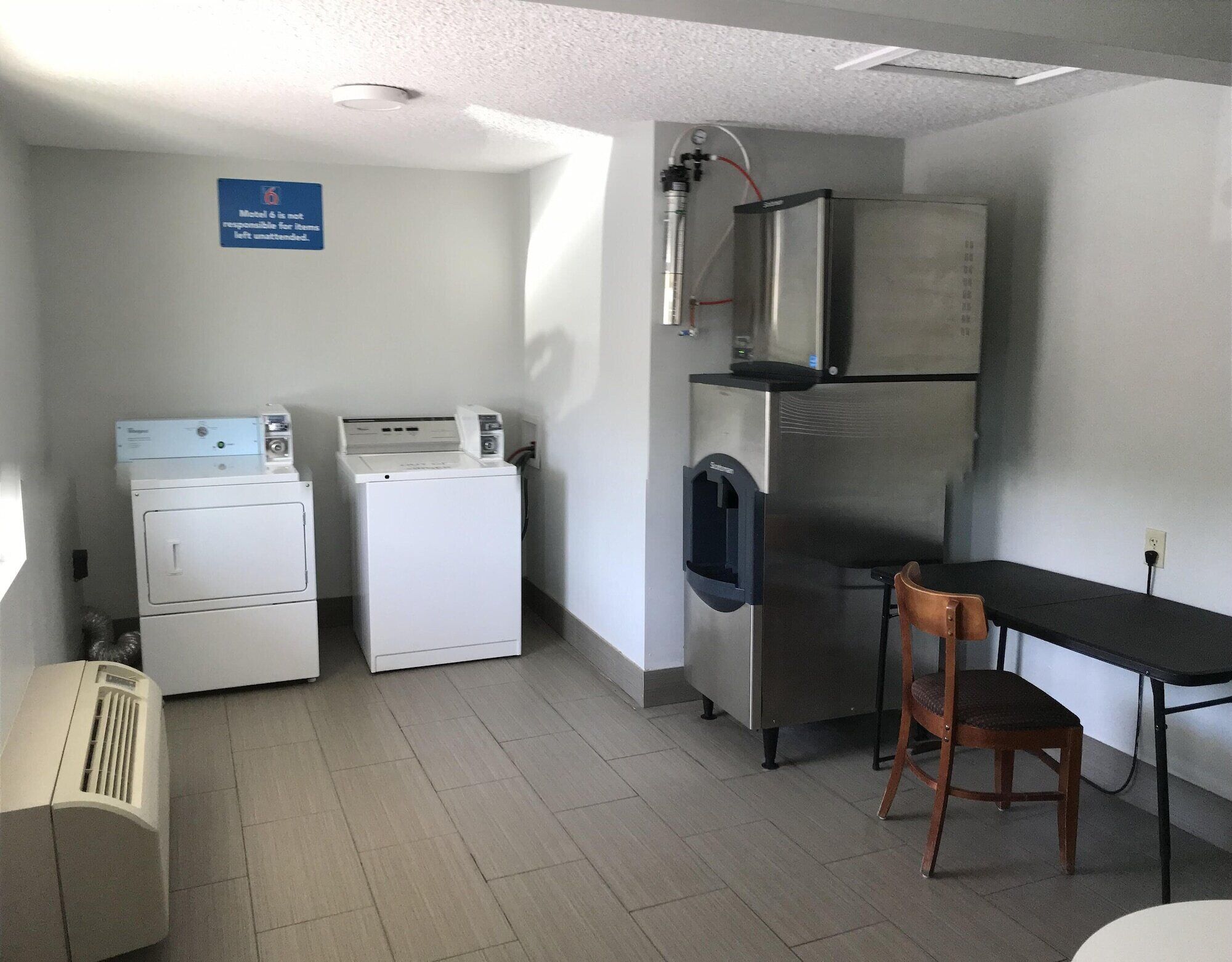 Een kleine keuken met een koelkast, magnetron en wasmachine.
