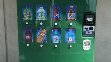 A green Mountain Dew vending machine with various drink options and a coin-operated interface.