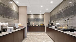 Un área de cocina moderna con una isla central, equipada con varios electrodomésticos y alimentos.