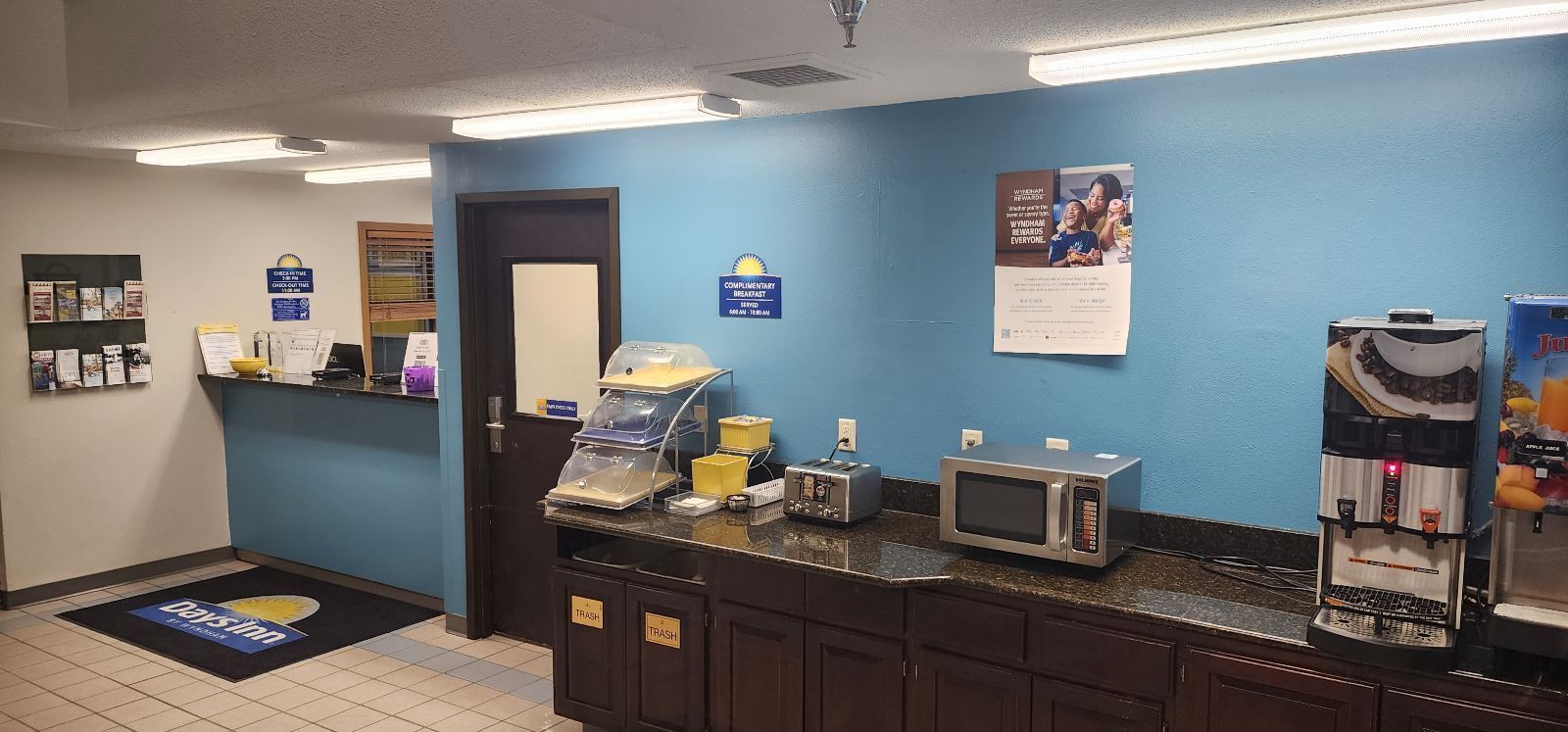 A hotel reception area with a coffee machine, microwave, and trash bins.