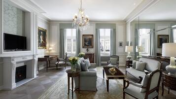 A spacious living room with a fireplace, elegant furniture, and large windows offering city views.