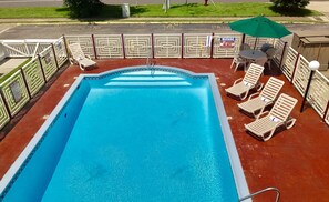 A swimming pool with lounge chairs and a warning sign. - Quality Inn Little Creek (Virginia Beach)