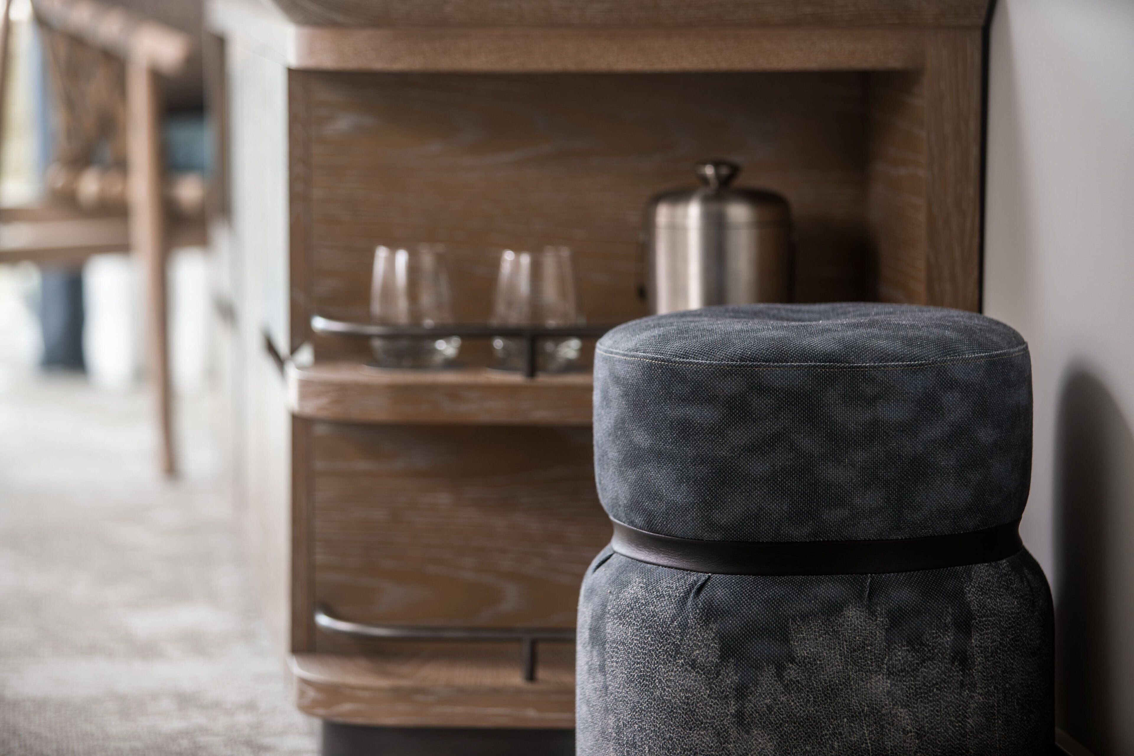Una cocina moderna con encimera de madera, una tetera de acero inoxidable y un juego de vasos de vidrio.