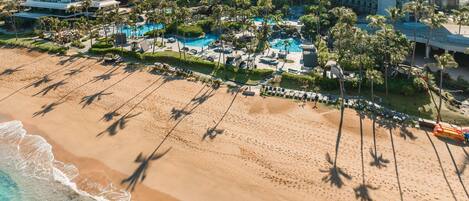 Un resort con playa, piscina y varios edificios de gran altura.