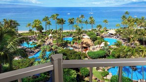 A resort with multiple swimming pools, palm trees, and a beach view.