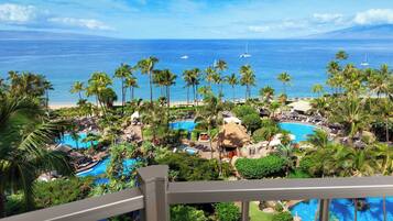 Relax by the pool surrounded by lush greenery and ocean views.