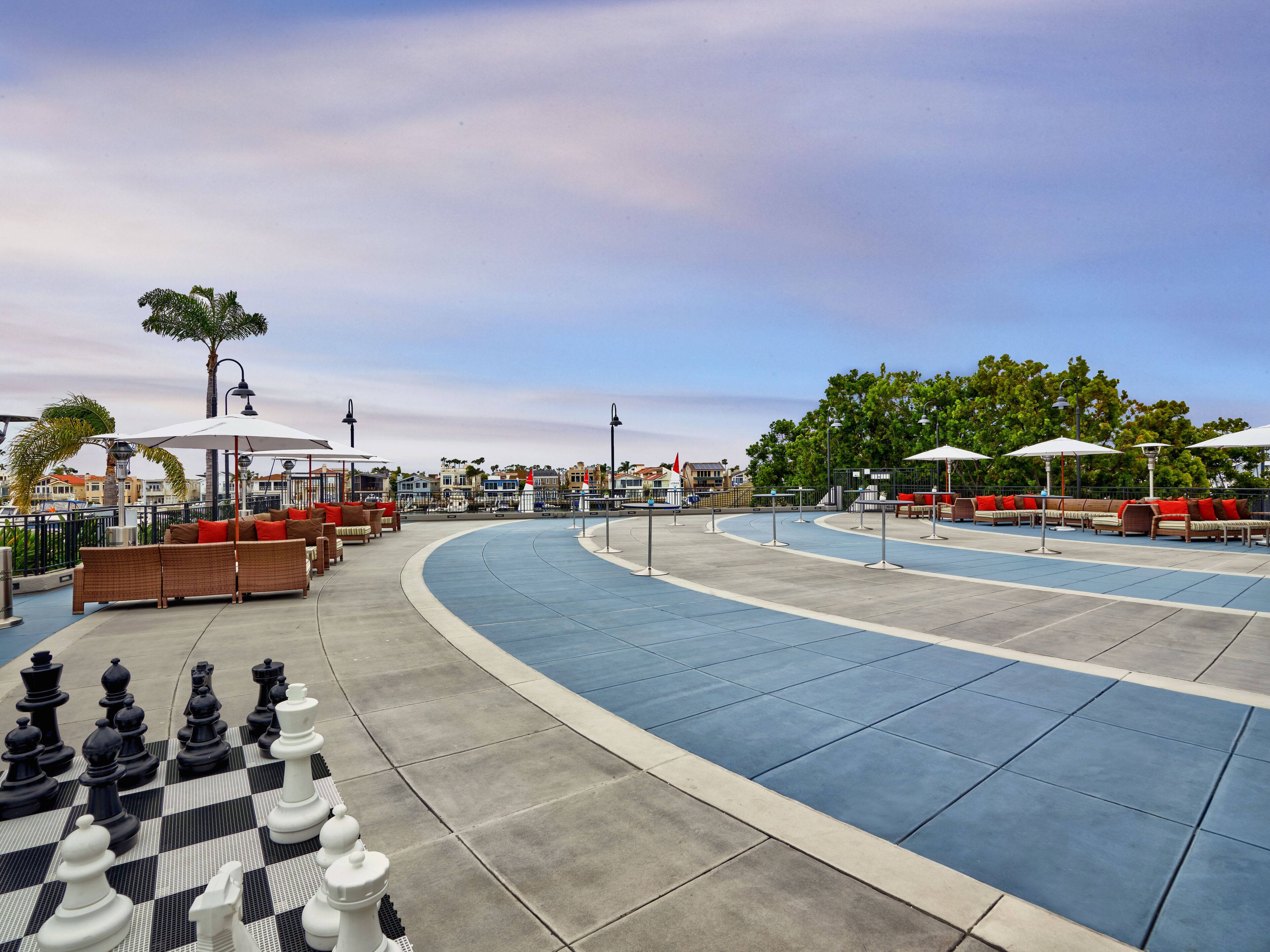 A boardwalk with outdoor seating and a large chess set.