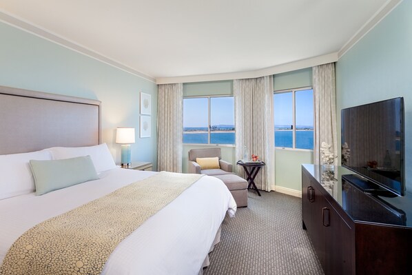 A hotel room with a large bed, a TV, a desk, and a view of the ocean. - Loews Coronado Bay Resort (Coronado)