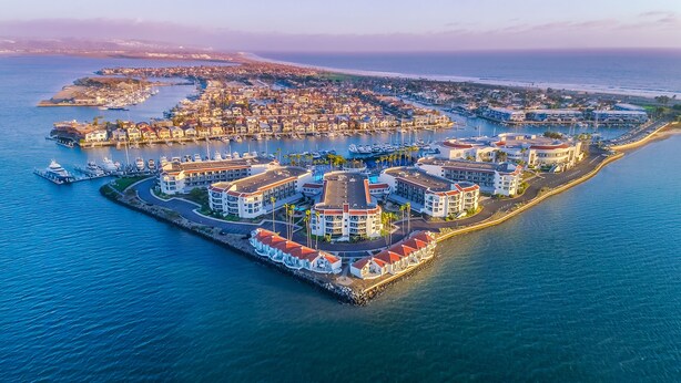 An aerial view of a coastal resort with multiple buildings, marina, and a pier. - Loews Coronado Bay Resort (Coronado)